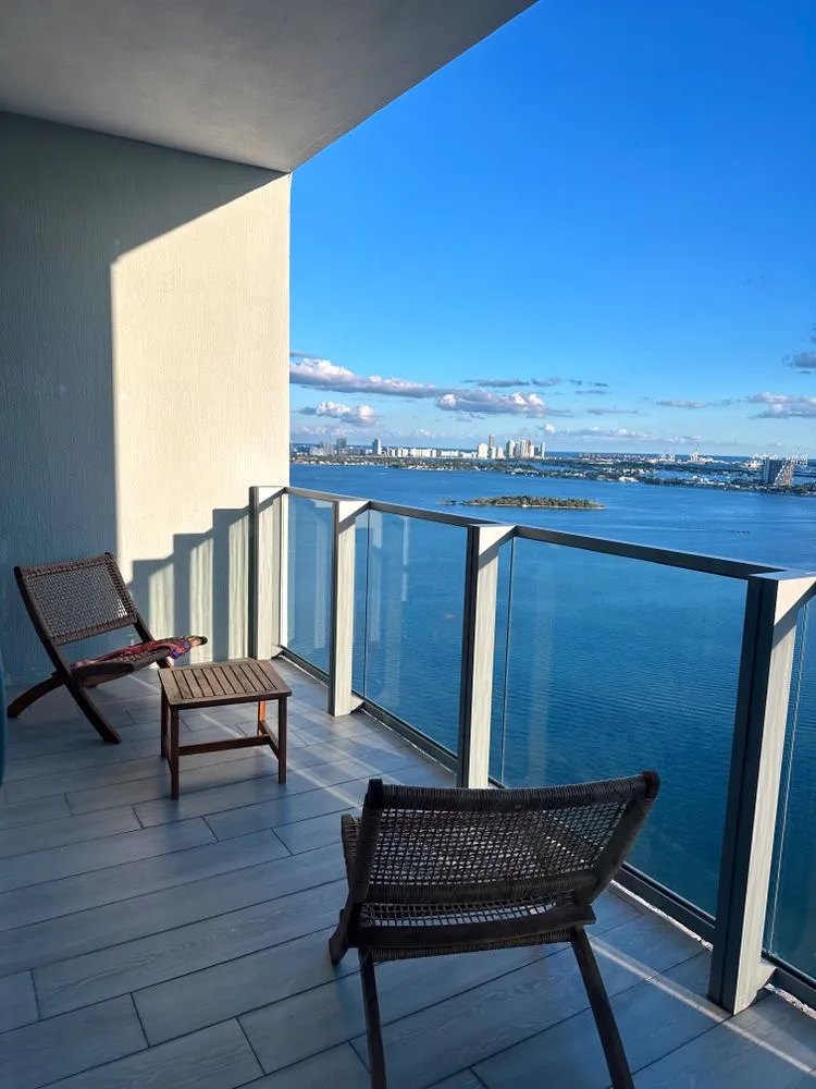 Example: high-rise balcony with timber-look tiles and glass balustrade over the water